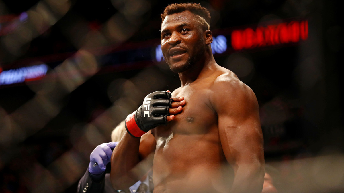 Francis Ngannou (red gloves) reacts after beating Junior Dos Santos (blue gloves) during UFC Fight Night at Target Center.